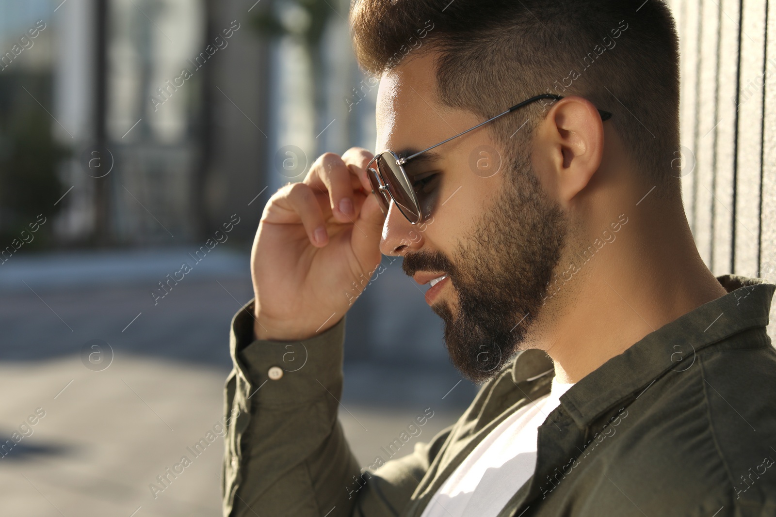 Photo of Handsome man in sunglasses outdoors, space for text