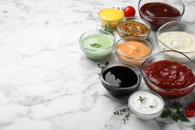 Photo of Many different sauces and herbs on white marble table. Space for text