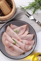 Photo of Tasty ham with rosemary served on white table, flat lay