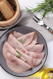 Tasty ham with rosemary served on white table, flat lay