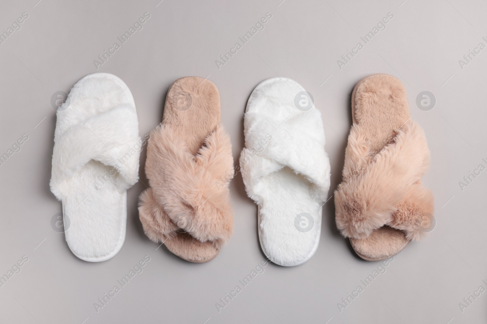 Photo of Different soft fluffy slippers on light grey background, flat lay
