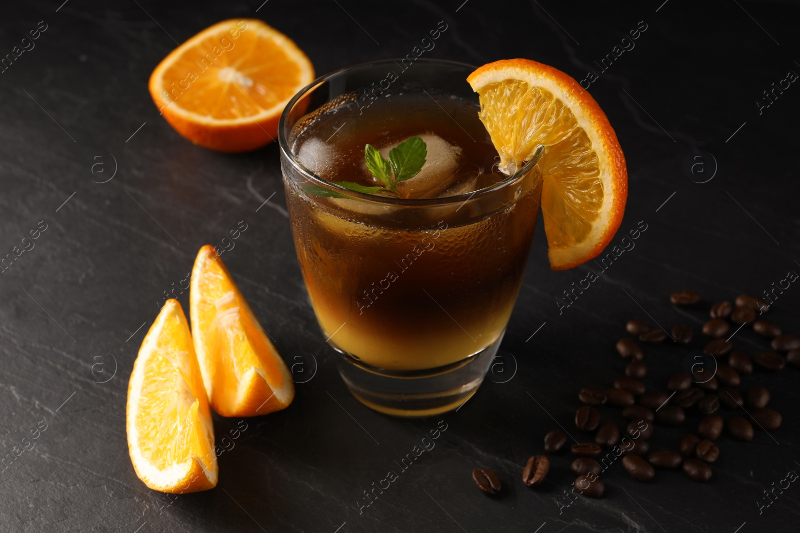 Photo of Tasty refreshing drink with coffee and orange juice on grey table