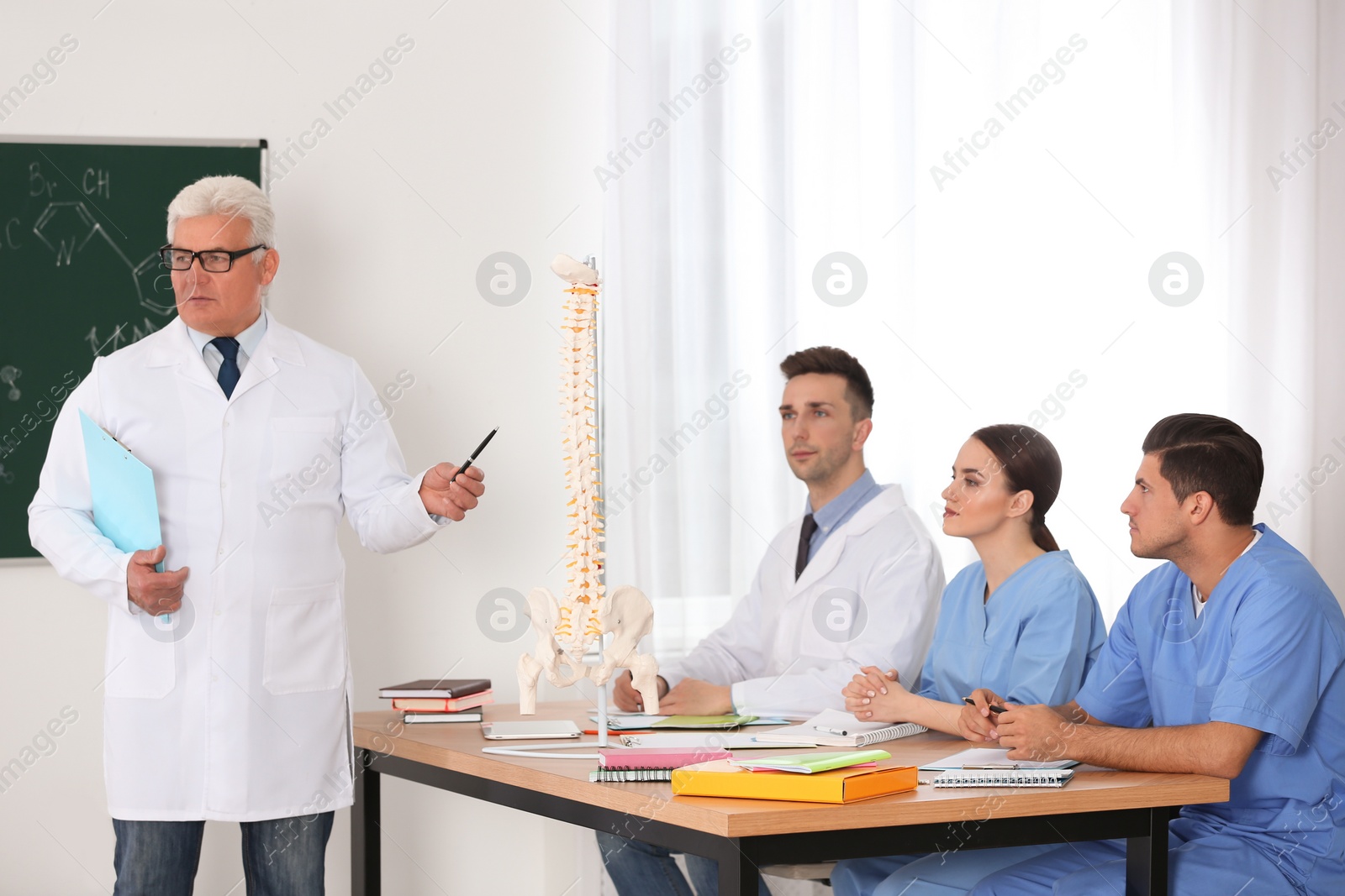 Photo of Medical students and professor studying human spine structure in classroom