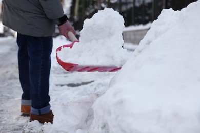 Photo of Man shoveling snow on city street, closeup