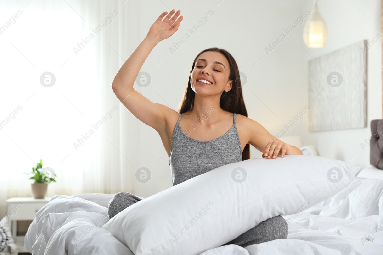 Photo of Portrait of beautiful young woman sitting on large bed