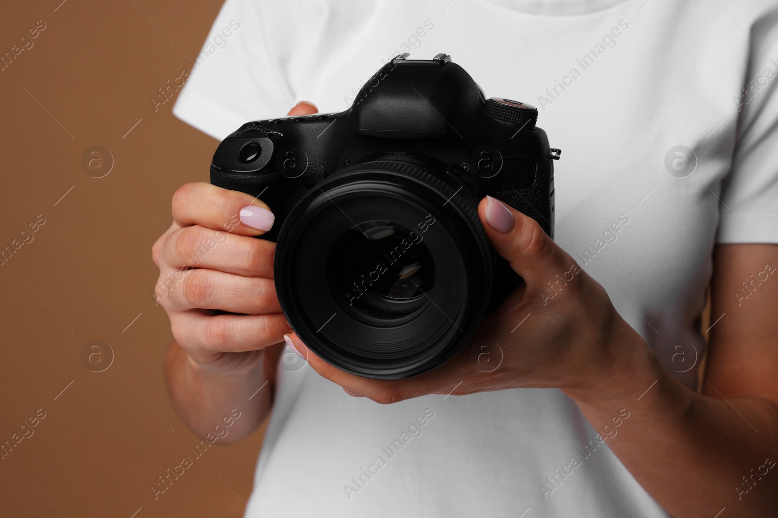 Photo of Photographer with camera on brown background, closeup