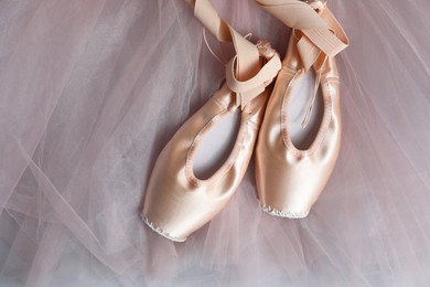 Photo of Ballet shoes. Elegant pointes and tutu on light grey background, top view. Space for text