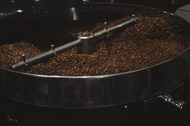 Modern coffee roaster machine with beans indoors, closeup