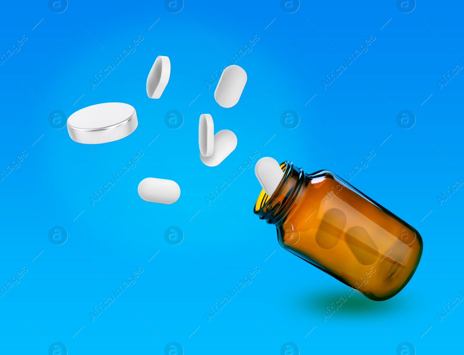 Image of Vitamin pills flying out from bottle on light blue background