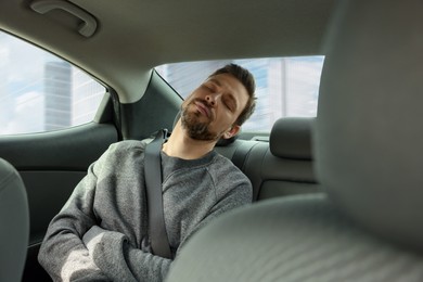 Tired handsome man sleeping in his modern car