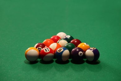 Photo of Many colorful billiard balls on green table