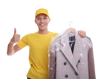 Photo of Dry-cleaning delivery. Happy courier holding coat in plastic bag and showing thumbs up on white background