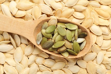 Wooden spoon on pumpkin seeds, top view