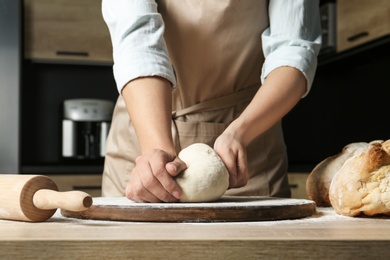 Photo of Female baker preparing bread dough at table, closeup