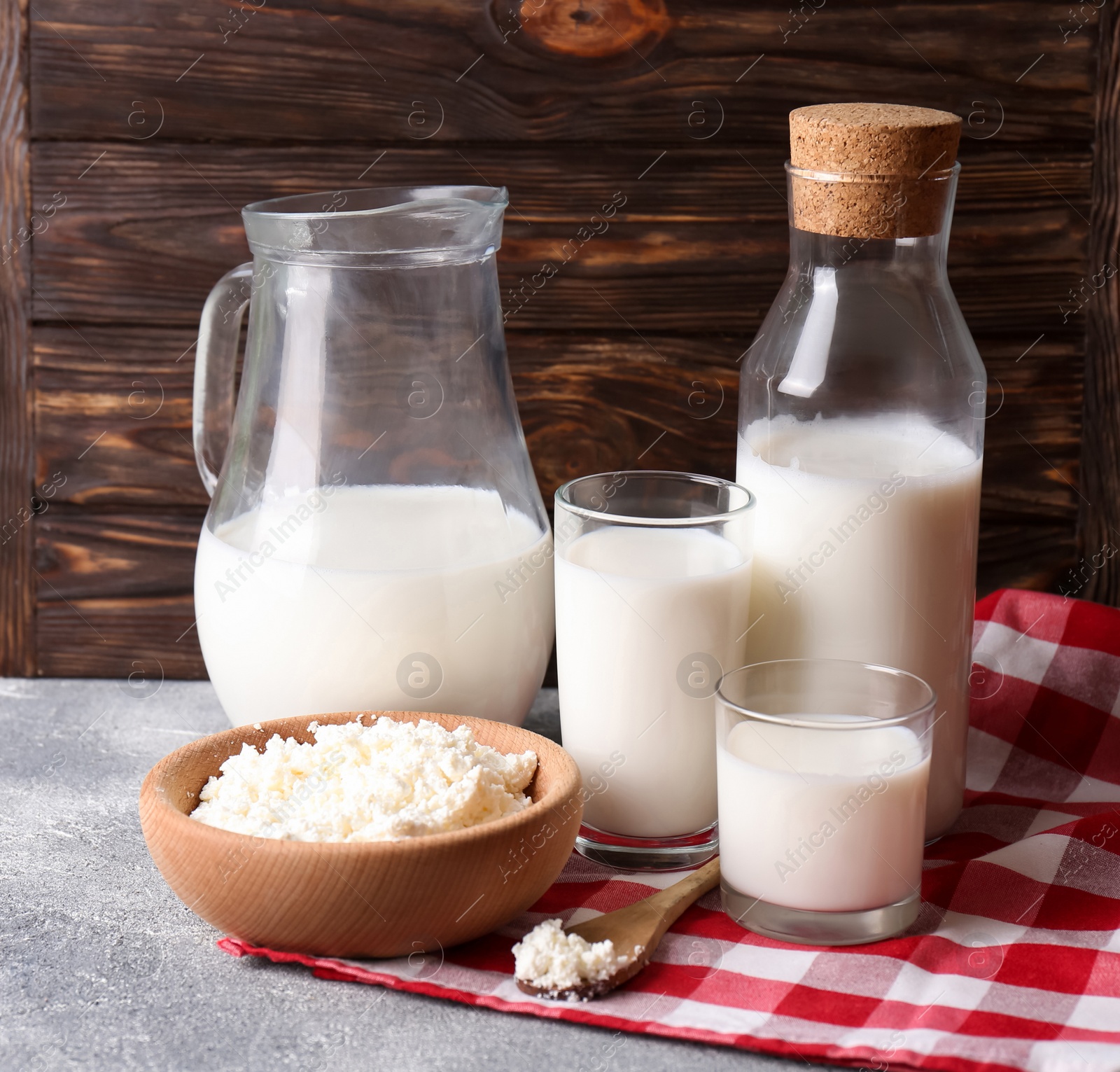 Photo of Tasty fresh milk and cottage cheese on grey table. Space for text