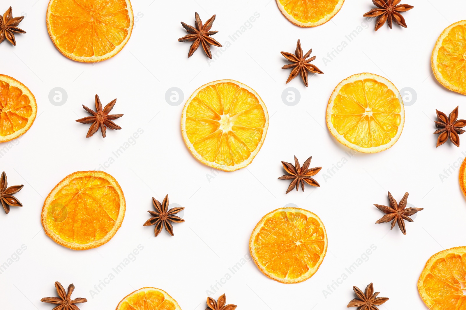 Photo of Dry orange slices and anise stars on white background, flat lay