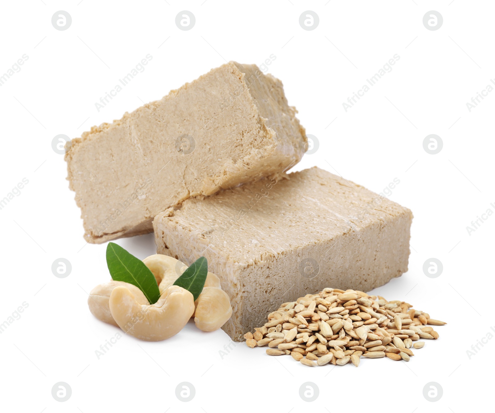 Image of Tasty halva, peeled sunflower seeds, cashew nuts and green leaves isolated on white