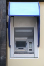Modern automated cash machine with screen outdoors