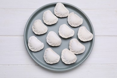 Raw dumplings (varenyky) on white wooden table, top view