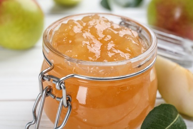 Delicious pear jam in glass jar on table, closeup