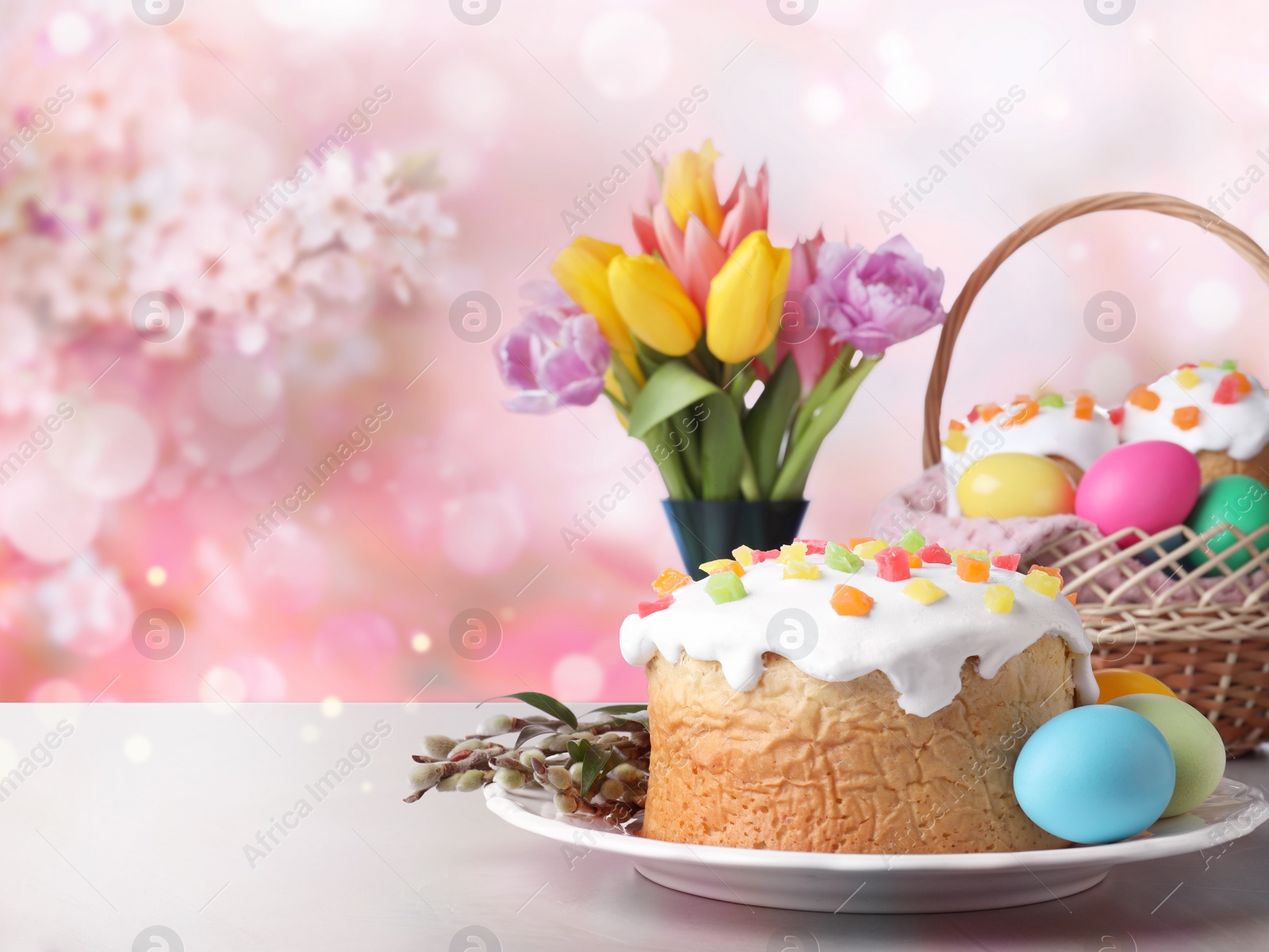 Image of Delicious Easter cakes and painted eggs on light grey table outdoors. Space for text