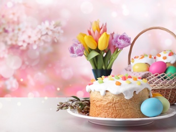 Delicious Easter cakes and painted eggs on light grey table outdoors. Space for text