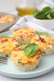 Photo of Freshly baked bacon and egg muffins with cheese on table, closeup