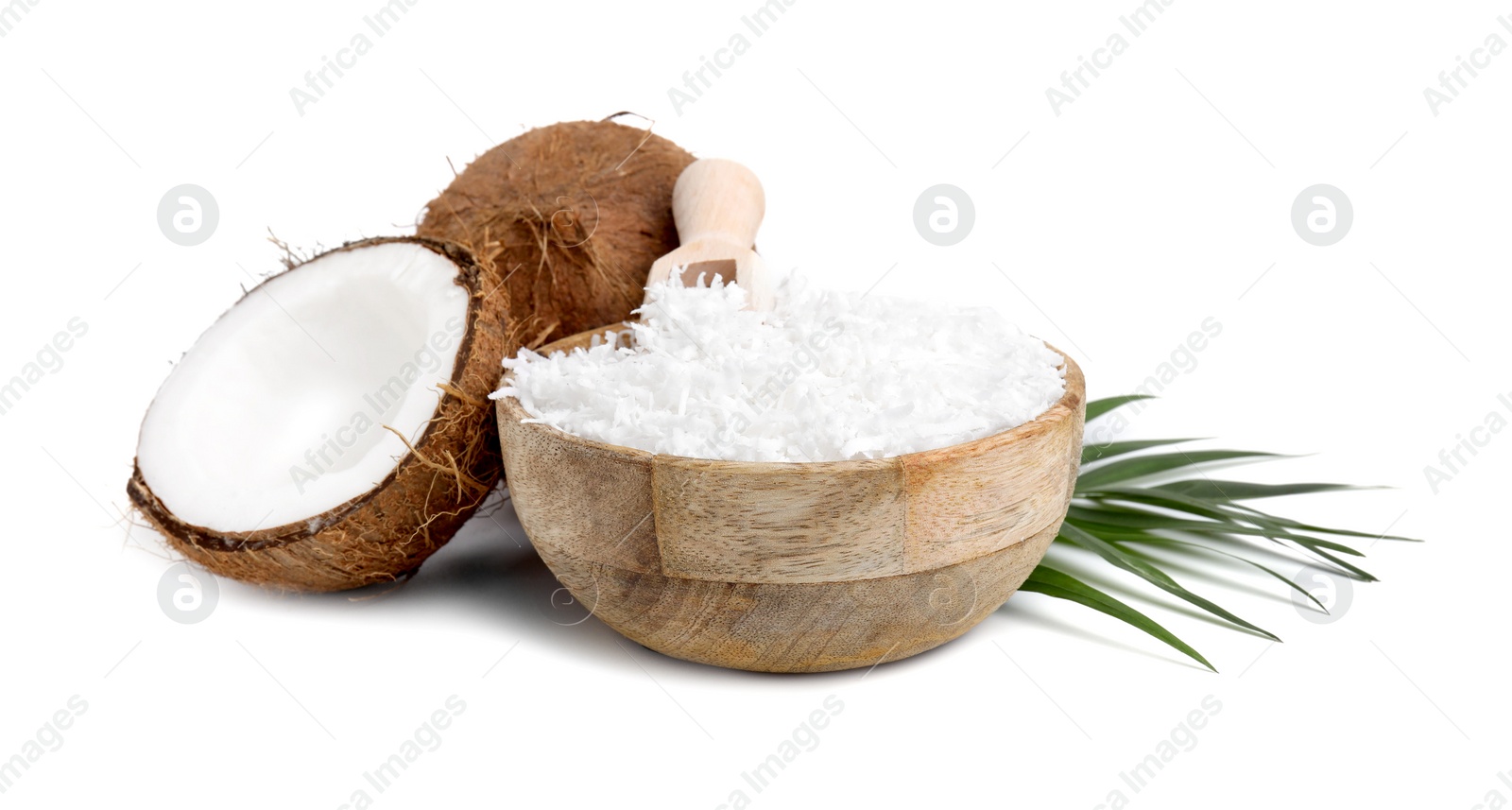 Photo of Coconut flakes in bowl, scoop, nuts and palm leaf isolated on white