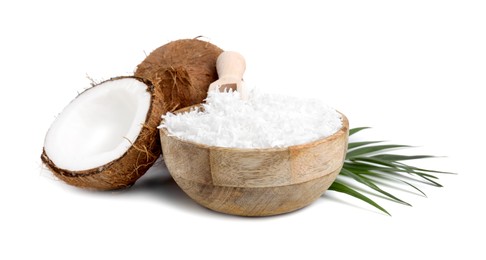 Coconut flakes in bowl, scoop, nuts and palm leaf isolated on white