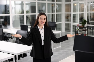 Happy female real estate agent in office