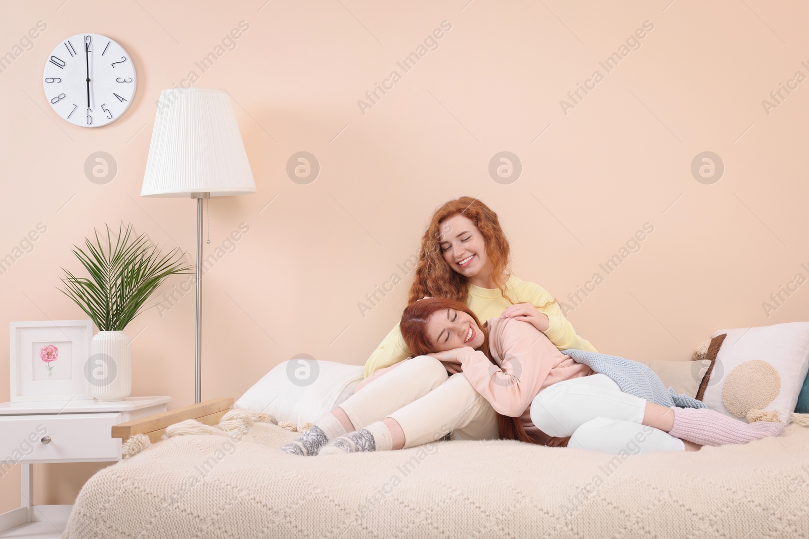 Photo of Portrait of beautiful young redhead sisters in bedroom