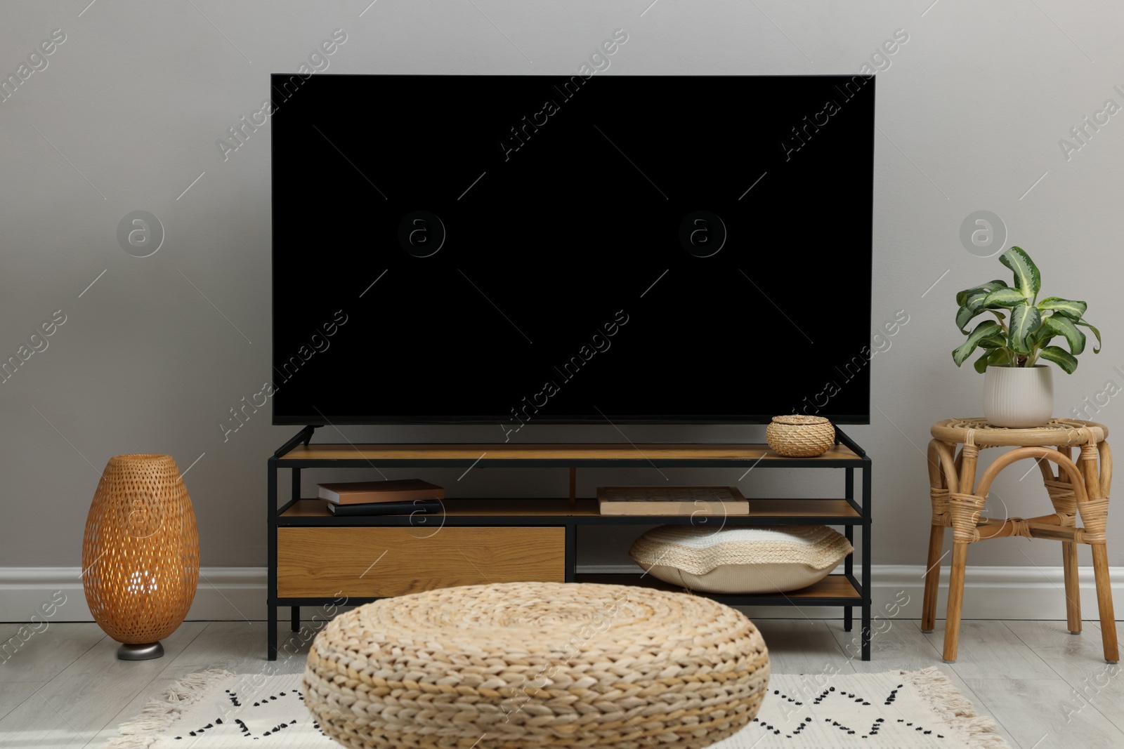 Photo of Stylish wide TV set on stand in room