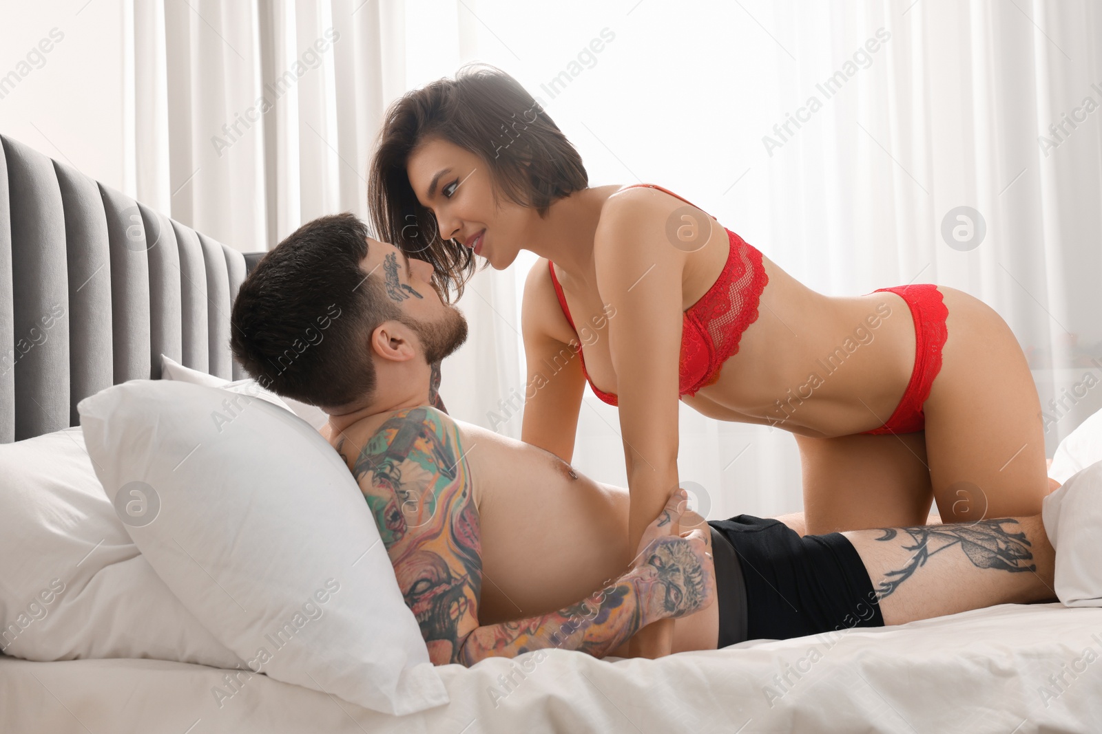 Photo of Passionate couple having sex on bed at home