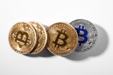 Golden and silver bitcoins on white background, top view. Digital currency