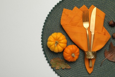 Photo of Cutlery, napkin and autumn decoration on white background, flat lay with space for text. Table setting