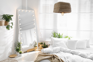 Photo of Stylish mirror with light bulbs in modern bedroom. Interior design