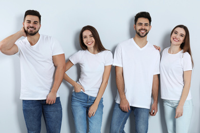Photo of Group of young people in stylish jeans on light background