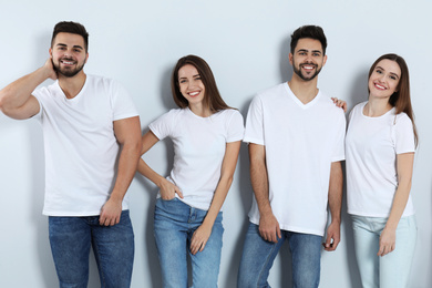 Group of young people in stylish jeans on light background