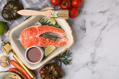 Photo of Fresh fish, lime, rosemary, marinade in baking dish and other products on light marble table, flat lay. Space for text