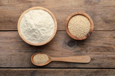 Quinoa flour in bowls and spoon with seeds on wooden table, flat lay