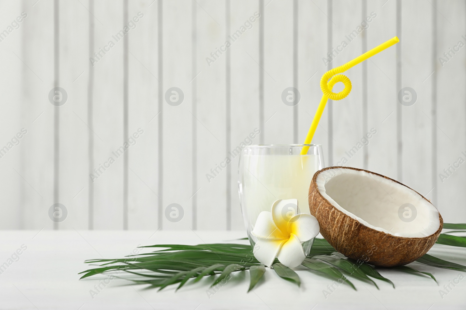 Photo of Composition with glass of coconut water on white wooden background