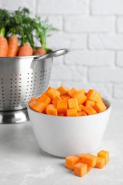 Photo of Bowl of fresh diced carrots on marble table