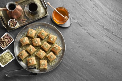 Photo of Delicious fresh baklava with chopped nuts served on grey table, flat lay and space for text. Eastern sweets