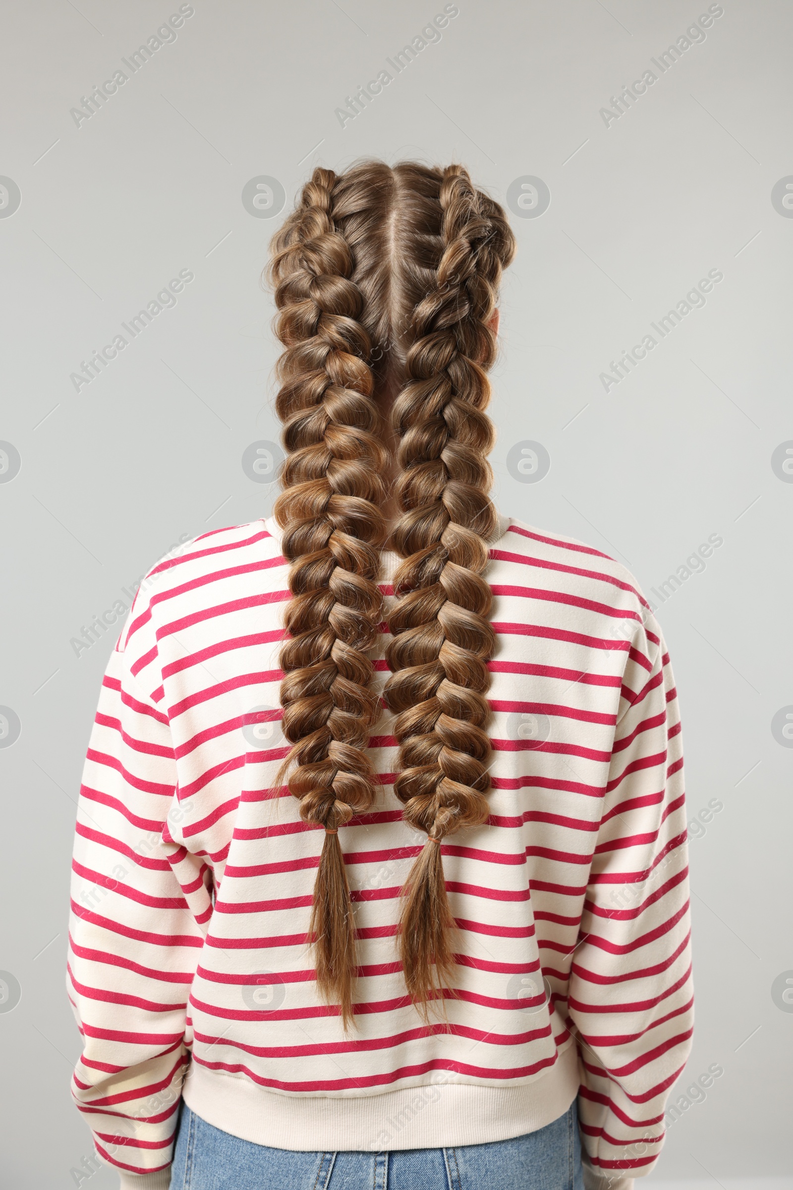 Photo of Woman with braided hair on grey background, back view