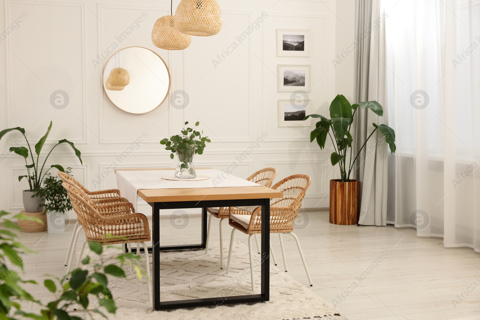 Photo of Stylish dining room with cozy furniture, mirror and plants