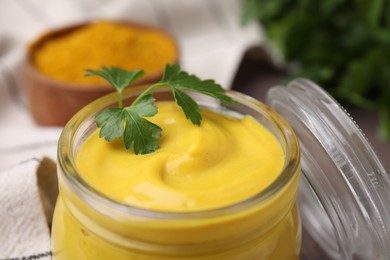 Photo of Jar with tasty curry sauce and parsley, closeup