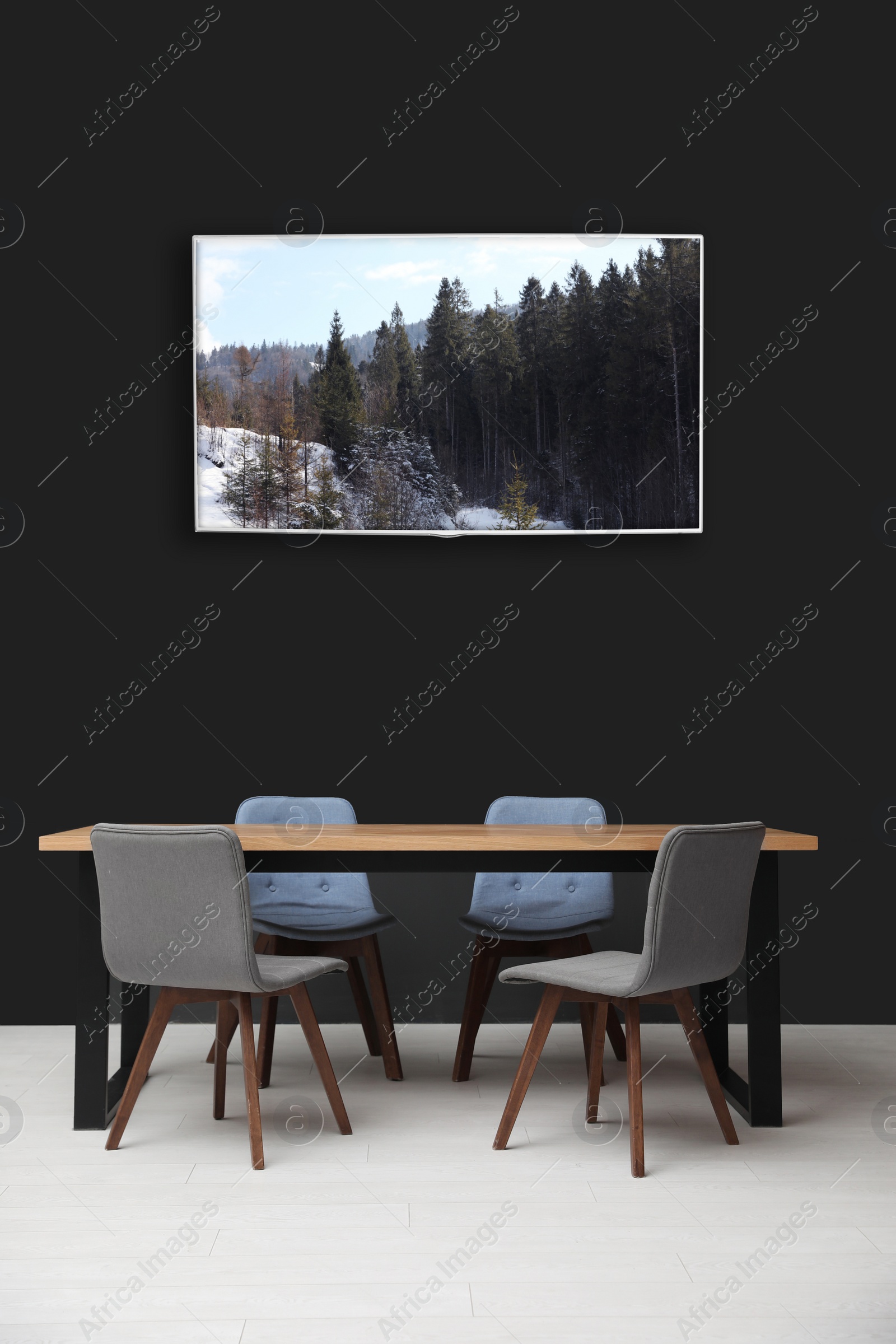 Image of Modern wide screen TV on black wall in room with stylish furniture 