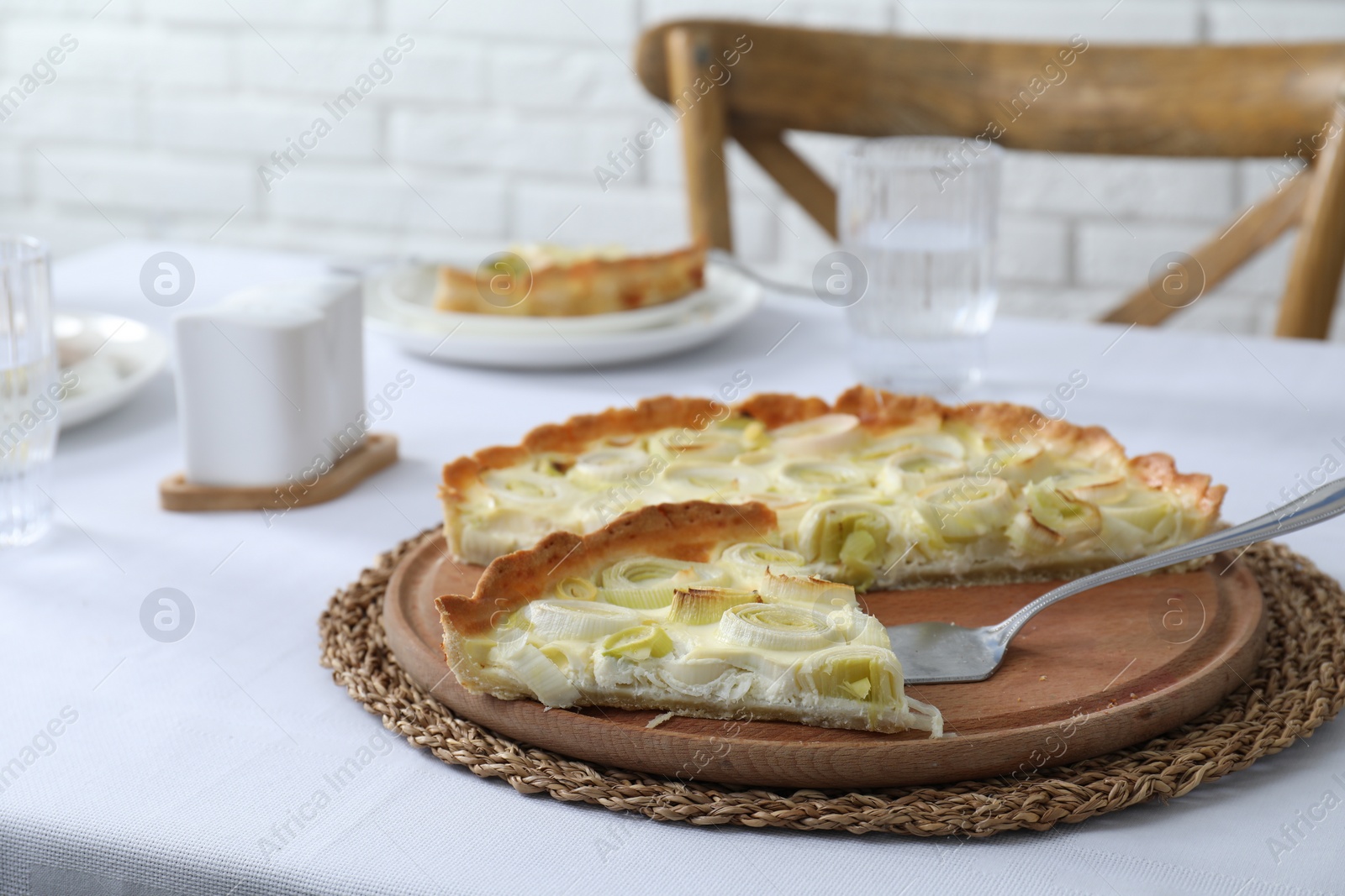 Photo of Board with tasty leek pie and cake server on table