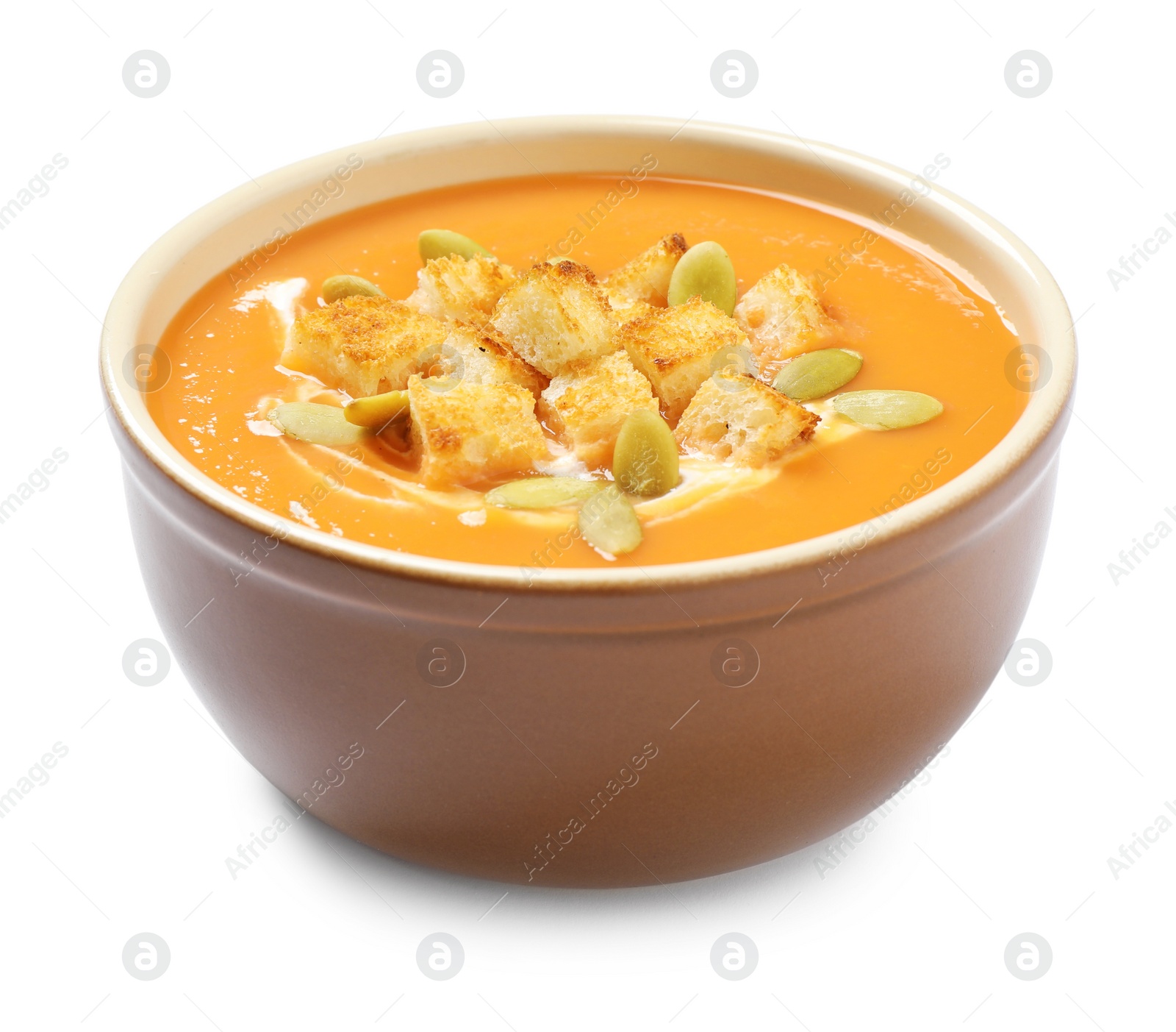 Photo of Tasty creamy pumpkin soup with croutons and seeds  in bowl on white background