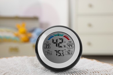 Digital hygrometer with thermometer on mat in room